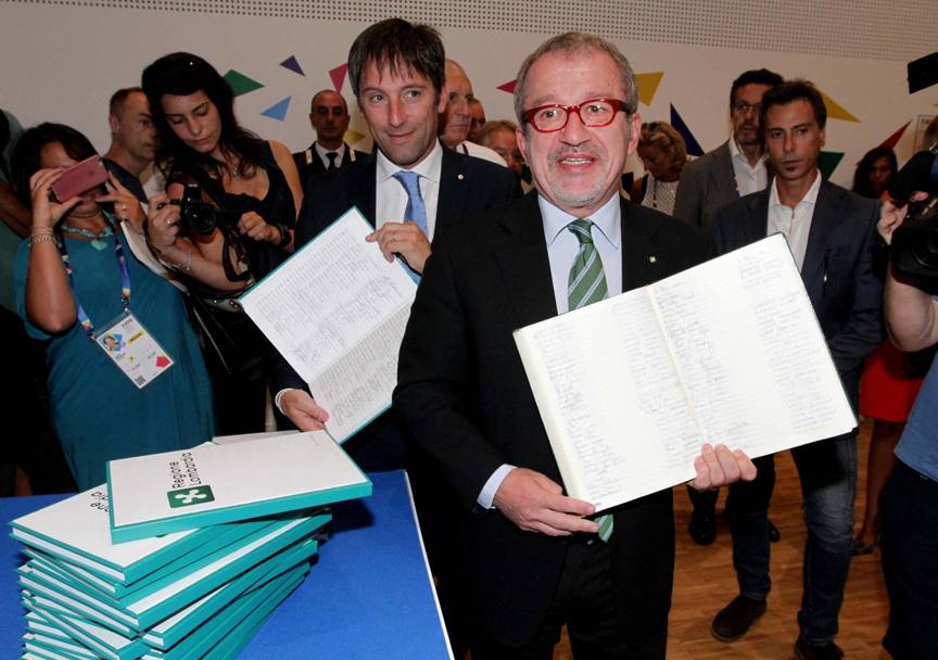 Il presidente della regione Lombardia, Roberto Maroni mostra le firme raccolte per la conferma del Gran Premio d&#39;Italia a Monza nel corso della conferenza stampa svoltasi ad Expo 2015. (Ansa)